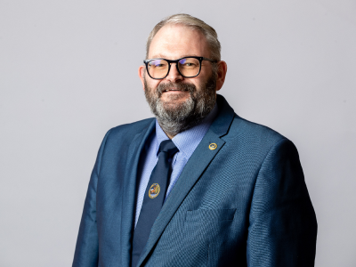 Headshot Mike young councillor in navy suit jacket, light blue shirt and matching navy tie