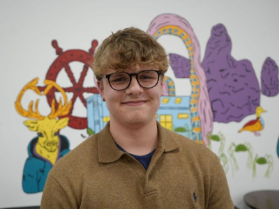 A photo of Oliver Dixon in a brown shirt and glasses