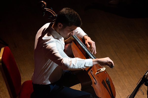 Applicant performing on stage with cello