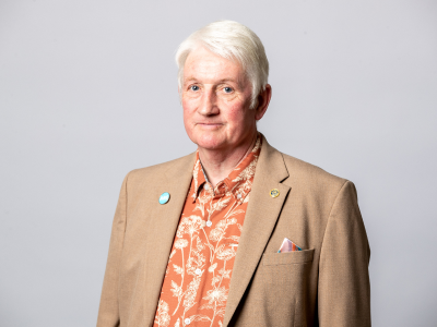 Headshot Rob darby councillor in brown suit jacket and orange shirt