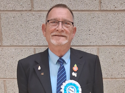 Headshot of Rob Stevenson in blue shirt, tie and suit jacket