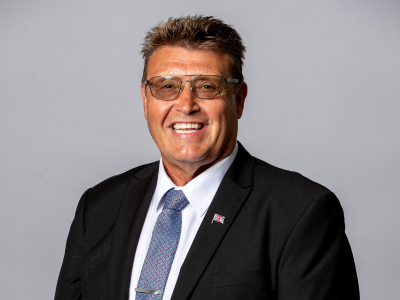 Headshot Ronnie buglass councillor in black suit jacket, white shirt and grey/blue tie