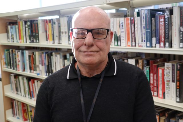 Paul Brazell in front of bookcase