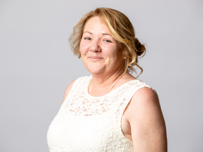 Headshot Sue little councillor in white lace dress with hair tied up