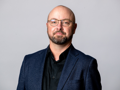 Headshot Tom feeney councillor in navy suit jacket and black shirt
