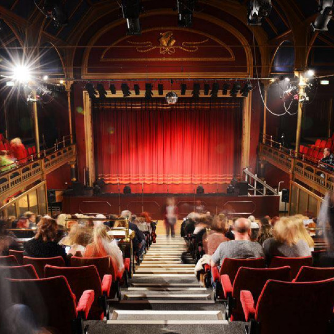 Stalls of town hall theatre with people taking their seats