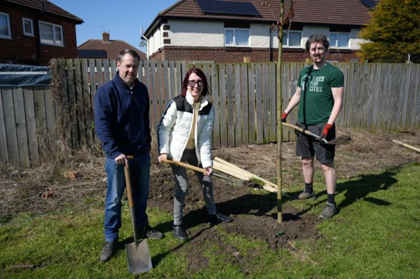 Councillor Brenda Harrison, the Leader of the Council, helps to plant one of the trees