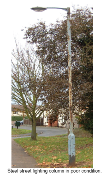 Street light on side of road on grassed area in poor condition